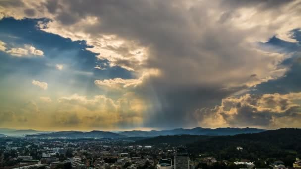 Raios de sol penetrando nuvens no céu celestial acima da montanha resort cidade, timelapse — Vídeo de Stock