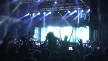 Kalabalık Led aydınlatma parlak ışınları altında dans müzik hayranları, konser