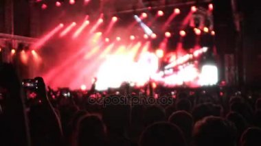 Heyecanlı kalabalık kırmızı parlak konser aydınlatma, yavaş dans