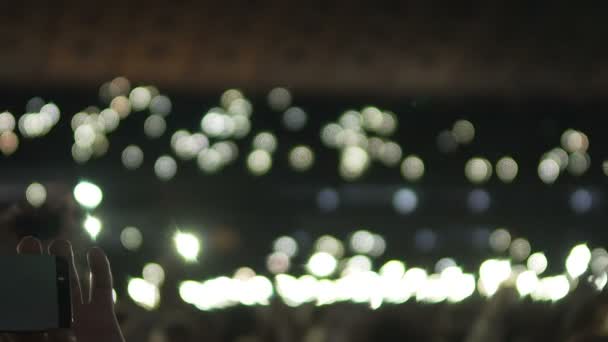 Personne filmant de nombreuses petites lumières scintillant dans l'obscurité lors d'un concert de musique — Video