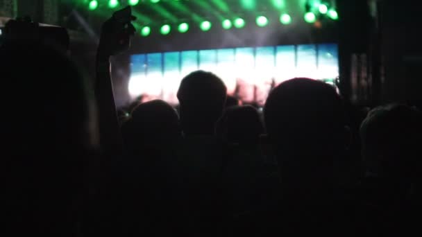 Menigte fans verwacht begin van de muzikale uitvoering, silhouetten, slow-motion — Stockvideo