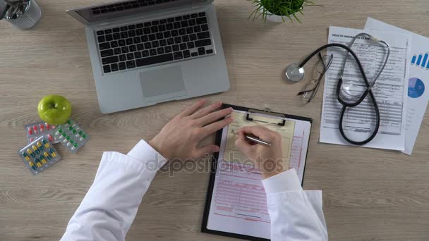 Therapeutiste remplissant le formulaire d'ordonnance et mettant signature, médecine, vue du dessus — Video