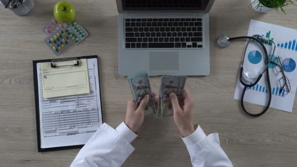Visão superior do trabalhador médico contando muitas notas de dólar, cuidados de saúde caros — Vídeo de Stock
