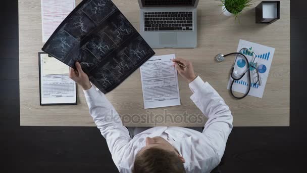 Hematologist holding scan of blood vessels in hands and thinking about diagnosis — Stock Video