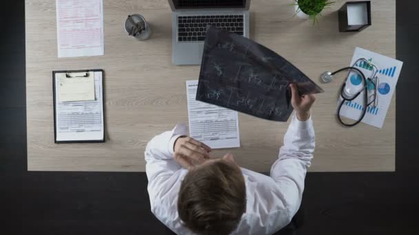 Neurologo avendo conversazione telefonica con il paziente, guardando la scansione dei vasi sanguigni — Video Stock