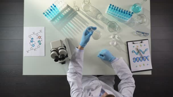 Biochemie onderzoeker toevoegen chemisch agens kolf, observatie van de reactie — Stockvideo