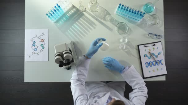 Estudiante de química mezclando agentes químicos en el frasco, realizando experimentos de color — Vídeo de stock