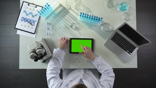 Vue du dessus de la tablette de défilement de travailleur de laboratoire avec écran vert, laboratoire moderne — Video