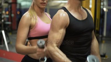 Genç kadın ve eğitmen halter kaldırma işi birlikte spor salonunda egzersiz