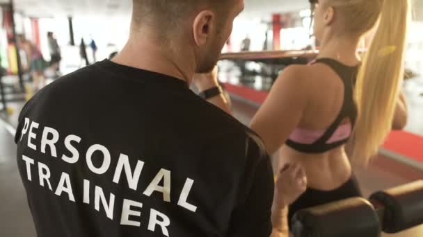 Sportschool trainer uitleggen pull-down techniek aan vrouwelijke stagiair, professionele helpen — Stockvideo