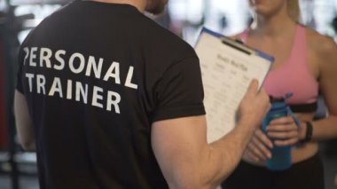 Kişisel antrenör haftalık jimnastik salonu kadın müşteri ile yemek planı tartışıyor