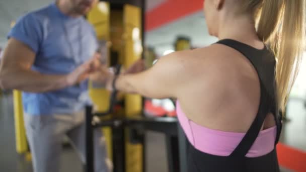 Персональный тренер поощряет клиента и вдохновляет ее продолжать делать упражнения — стоковое видео