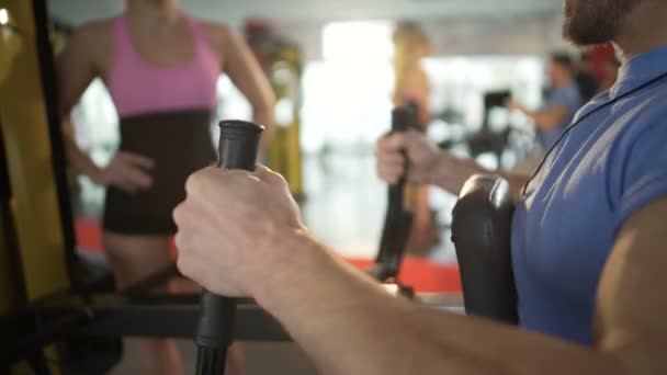 Hombre haciendo ejercicio en el gimnasio, atrayendo la atención de la hermosa mujer rubia, coquetear — Vídeos de Stock