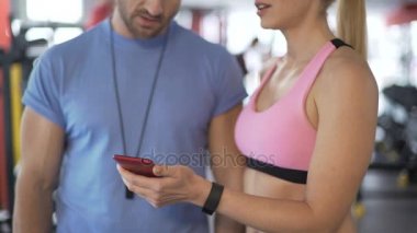 Uygun Bayan spor salonunda kişisel antrenör için onun sonuçlarını izleme uygulamasını gösteren