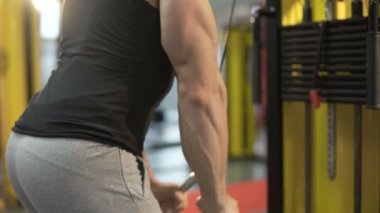 Spor salonunda çalışkan pompalama kol ve omuz kasları, genç seksi adam