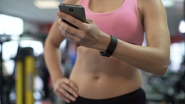 Mujer revisando sus datos de actividad física en la aplicación móvil después del entrenamiento — Vídeo de stock