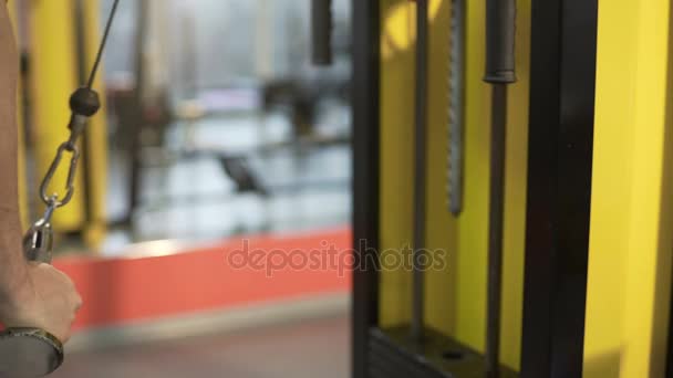 Hombre haciendo ejercicios en la estación de fitness, bombeo de hierro para desarrollar sus músculos — Vídeos de Stock