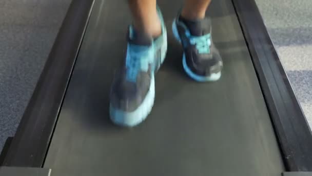 Piernas de hombre atlético corriendo en la cinta de correr, entrenamiento cardiovascular en el gimnasio — Vídeos de Stock