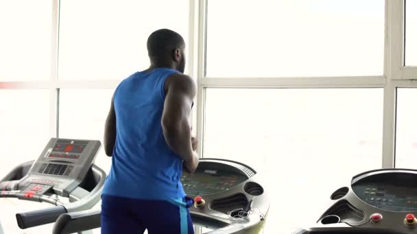 Muscular Afro-American man running on treadmill in the gym, workout, sport — Stock Video