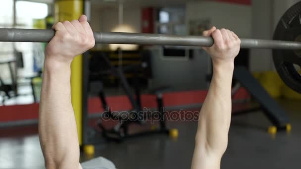 Primer plano del atleta fuerte levantando la barra en el gimnasio, levantamiento de pesas, deporte — Vídeo de stock