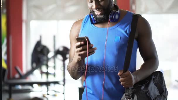 Hombre atlético guapo leyendo el mensaje en el teléfono móvil con sonrisa feliz en la cara — Vídeo de stock