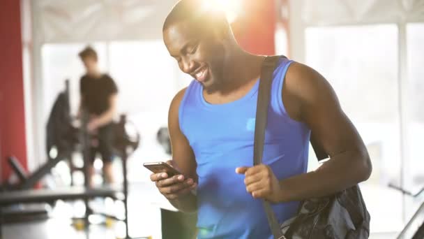 Jovem feliz verificando mensagens no smartphone com rosto sorridente surpreso — Vídeo de Stock