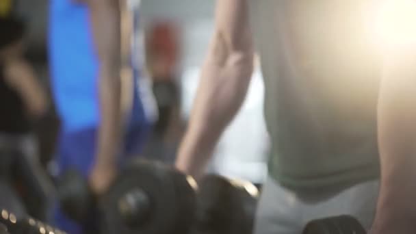 Jovens ativos exercitando-se na academia juntos, construindo corpos musculares, treino — Vídeo de Stock