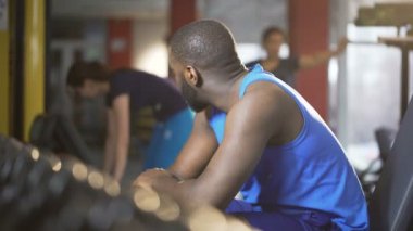 Yakışıklı kendine güvenen adam gülümseyerek ve flört bayanlara jimnastik salonu, bakan