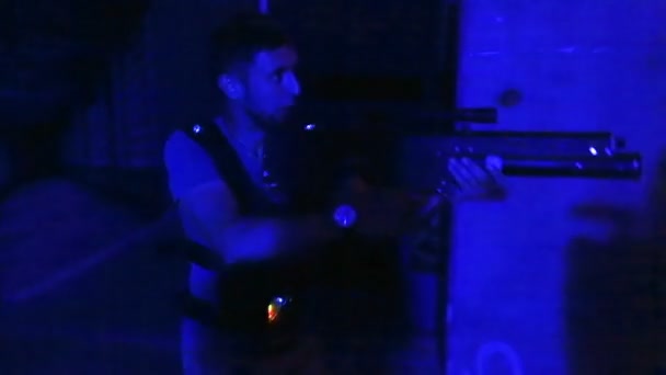 Jogador masculino se escondendo de rival com arma de lasertag, desfrutando de jogo de combate realista — Vídeo de Stock