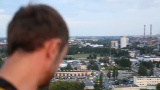 Крайний мужчина кровельщик, смотрящий с вершины небоскреба, адреналиновый наркоман — стоковое видео