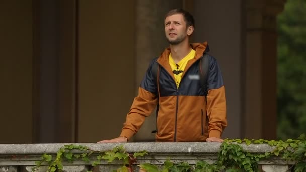 Touristes debout sur le balcon recouvert de lierre et bénéficiant d'une vue sur l'église de Mirogoj — Video