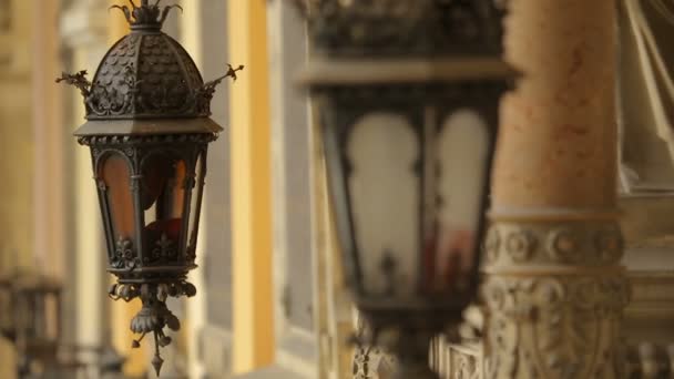 Красивые винтажные лампы, висящие на средневековом здании, древняя архитектура — стоковое видео