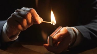 Kibrit kutusu tutarak ve maç yanan erkek eller hayat hızlı, yavaş hareket tarafından geçer.