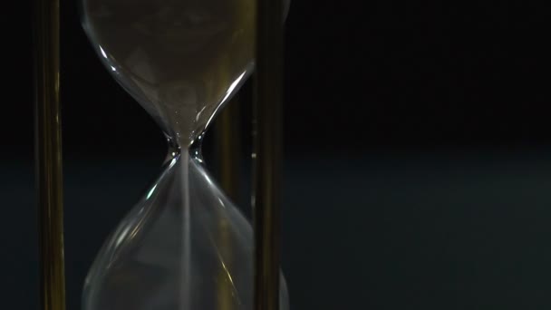 Hourglass with white sand running out, ruthless time flies fast, slow-motion — Stock Video