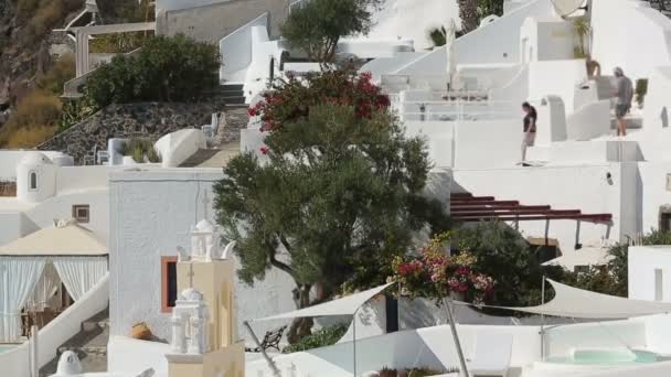 Turistas viendo la arquitectura de Santorini, disfrutando de vacaciones de verano en Grecia — Vídeos de Stock