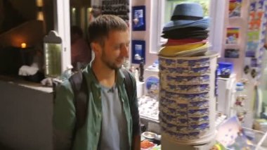 Erkek turistik Hediyelik eşya dükkanına gelen hediyeler yüzünde mutlu gülümseme ile seçme