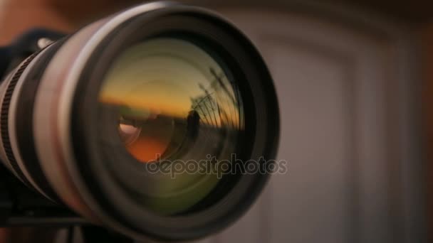 Homem posando contra o pôr do sol, reflexão na lente da câmera, jornalista no trabalho, hobby — Vídeo de Stock