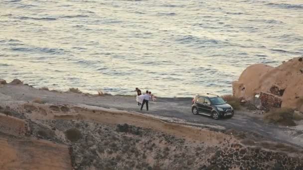 Feliz pareja recién casada disfrutando de la sesión de fotos de boda en la costa romántica — Vídeos de Stock