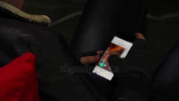 少年滚动照片上他的智能手机，选择哪一个在博客中发布的 — 图库视频影像