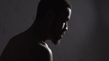 Üzgün Afro-Amerikan adam oturmuş boş oda, depresyon ve melankoli, duygular