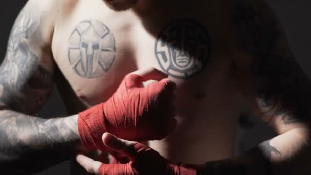 Concentrado Muay Thai boxeador masculino envolviendo vendajes en sus manos, lento-mo — Vídeo de stock