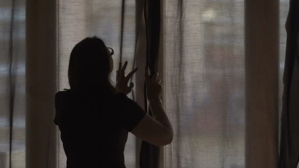 Mulher abrindo cortinas escuras deixando sol quente verão em sua casa aconchegante, câmera lenta — Vídeo de Stock