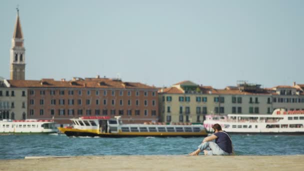 Kvinnan sitter på piren och läsebok, Canal Grande i Venedig, avkoppling — Stockvideo