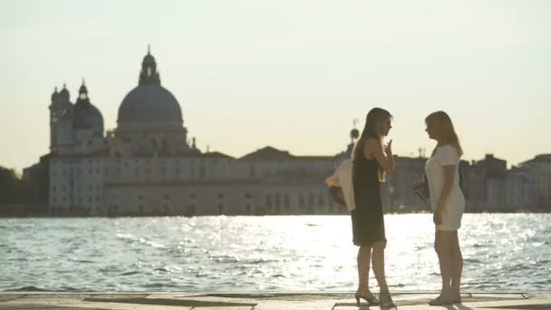 Venedig, Italien, Circa juni 2016: Sightseeing i staden. Två vänner står på piren och pratar, väntar vattenbussen i Venedig — Stockvideo