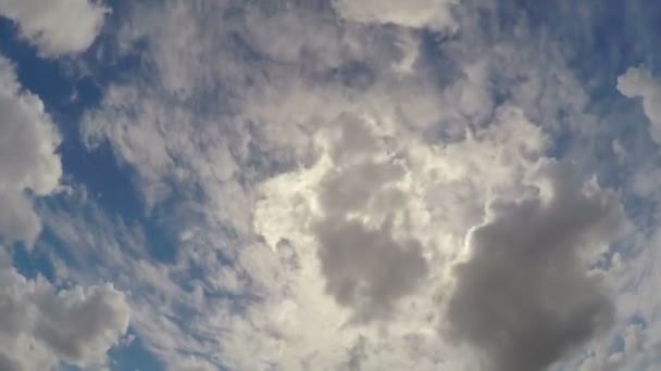 Nubes humeantes a la deriva en el cielo, ocultando periódicamente el sol en el clima ventoso de verano — Vídeos de Stock