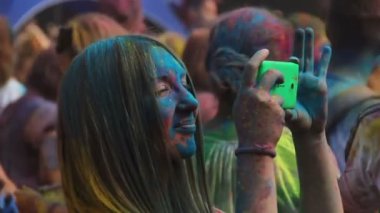 Kiev, Ukrayna - 9 Ağustos 2015: Holi renkli kutlama Festivali. Mutlu kız renkli boya renk fest smartphone cep telefonu ile anları filme kaplı
