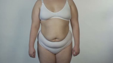 Kamera için poz ve obezite, dönüm iç çamaşırı giyen kadın kilolu