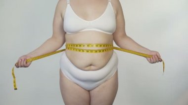 Obez kadın beline beyaz iç çamaşırı, motivasyon ve diyet ölçme