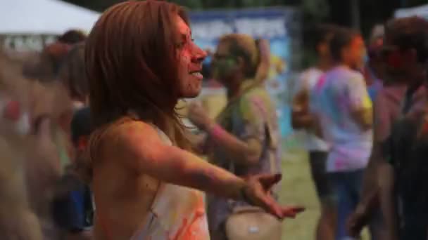 KIEV, UCRÂNIA - 9 de agosto de 2015: Celebração do festival Holi Color. Garota excitada coberta de tinta colorida pulando e dançando no festival Color — Vídeo de Stock