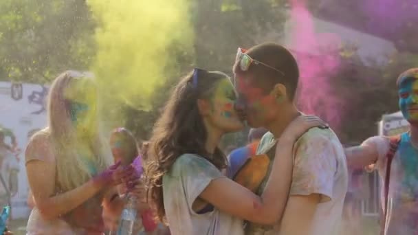 KIEV, UKRAINE - HARUS 9, 2015: Perayaan Holi Color festival. Pasangan yang jatuh cinta dengan penuh kasih berciuman di festival Warna di awan bubuk terang — Stok Video